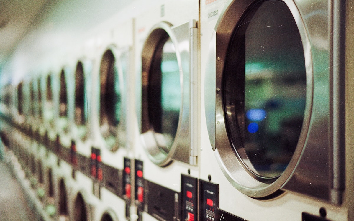Row of professional laundry machines mid-cycle